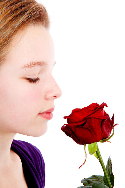 Jovem cheirando uma rosa vermelha em close-up
 - Foto, Imagem