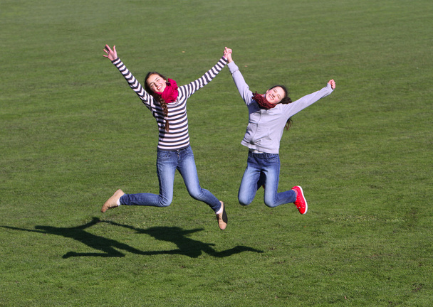 Teenage girls jumping on the stadium. - Zdjęcie, obraz