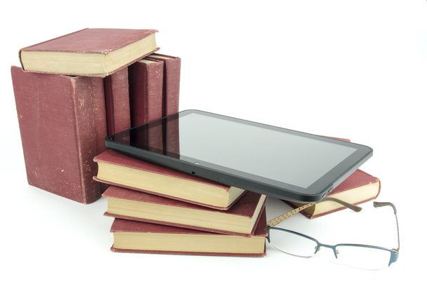 E-boek tablet met stapel afgedrukt van oude boeken en glazen - Foto, afbeelding