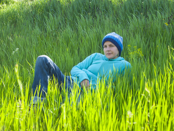 Молода дівчина відпочиває на траві
. - Фото, зображення