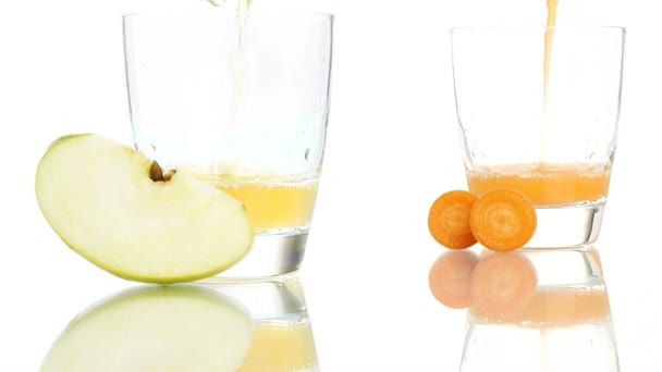 Apple en wortel sap gegoten aan het glas geïsoleerd op witte achtergrond - Video