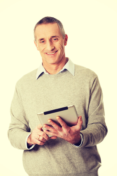 Happy mature man using digital tablet - Photo, image