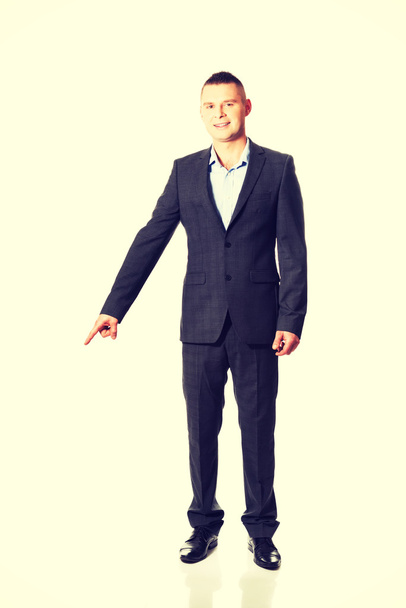 Young businessman pointing down - Foto, Imagen