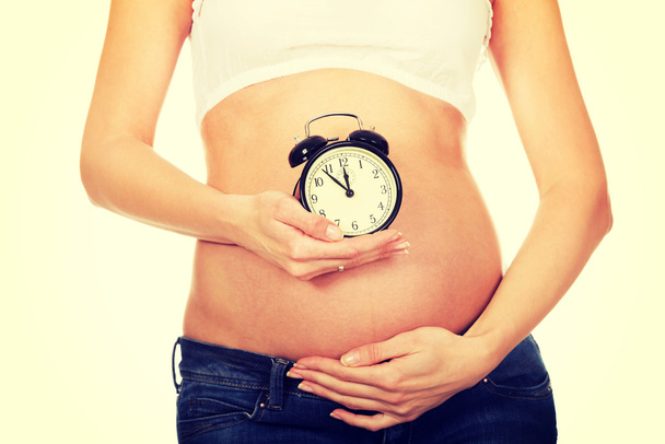 Pregnant woman with an alarm clock - Foto, Imagem