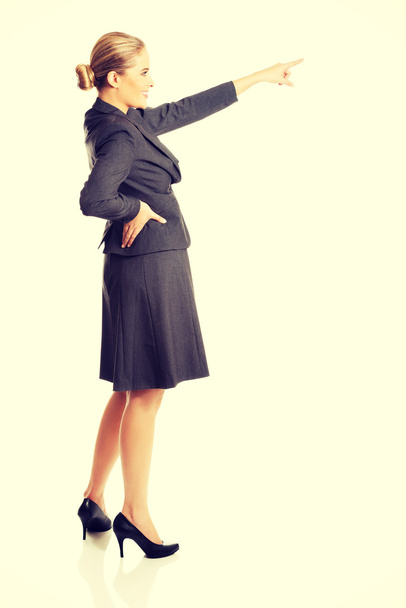 Businesswoman pointing high on copyspace - Zdjęcie, obraz