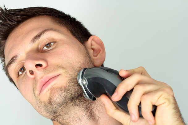 Homme rasage visage avec rasoir électrique
 - Photo, image