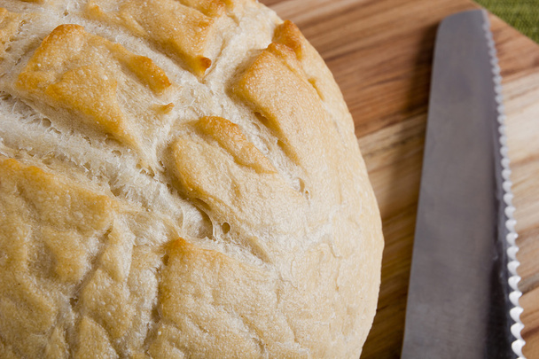 Round bread and a knife saw - 写真・画像