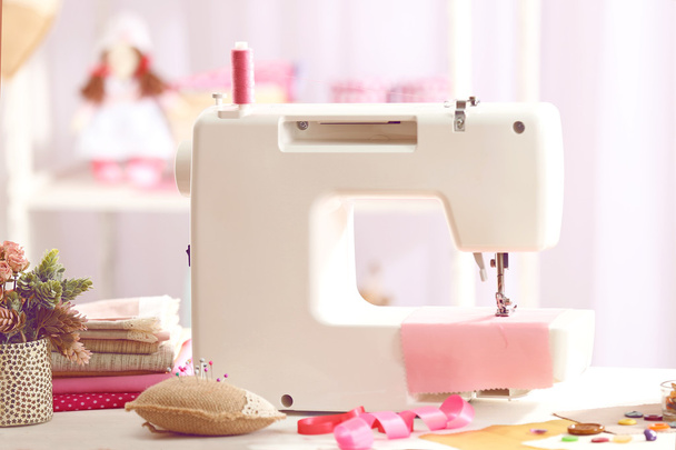 Sewing machine on table in workshop - Fotó, kép