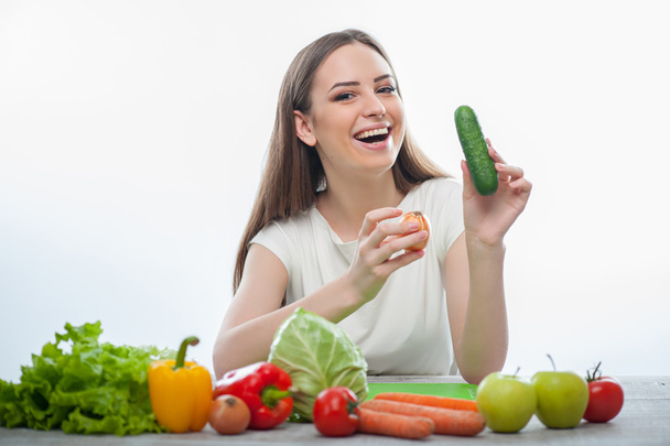 Pretty woman is sitting with fruits and vegetables - Foto, afbeelding