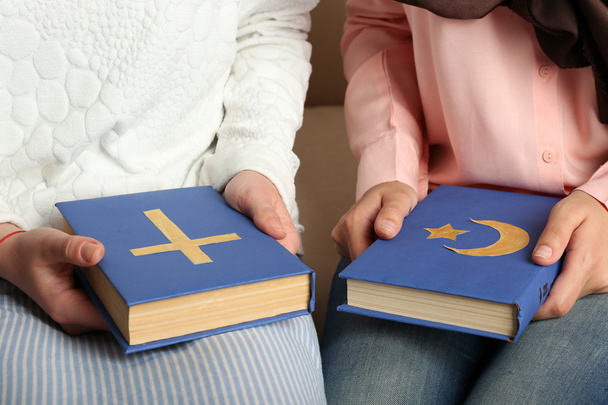 Two friends holding books with religions symbols - Photo, image