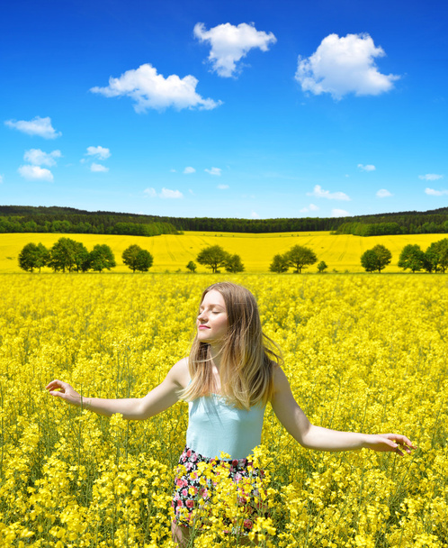 Jeune femme heureuse sur le champ de colza en fleurs
 - Photo, image