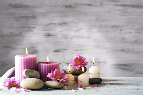 Beautiful composition with candles and spa stones on wooden background - 写真・画像