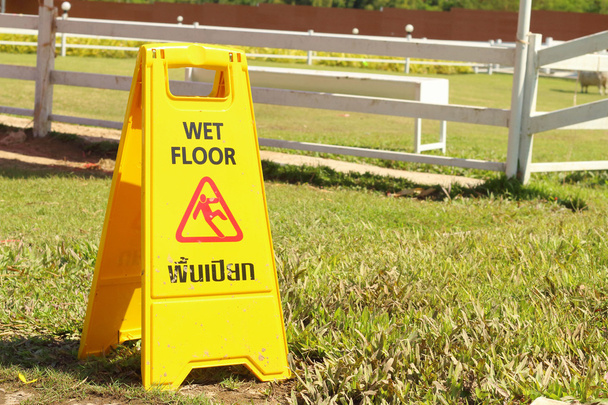 Κίτρινο σημάδι προειδοποίησης για υγρό πάτωμα στο πάρκο - Φωτογραφία, εικόνα