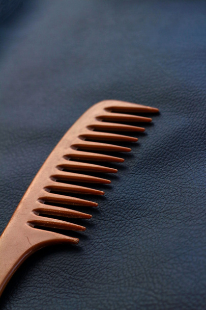 A wooden comb on a nevy blue background - Valokuva, kuva
