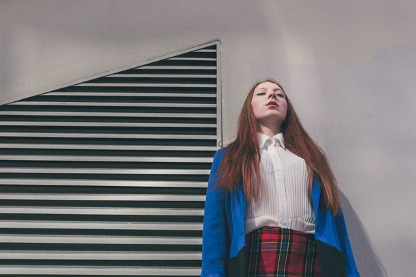 Beautiful redhead girl posing in an urban context - Valokuva, kuva