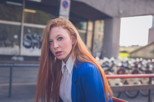 Beautiful redhead girl posing in an urban context - Foto, afbeelding