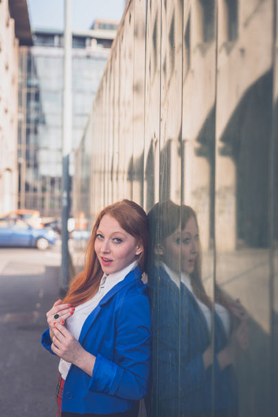 Beautiful redhead girl posing in an urban context - Foto, immagini