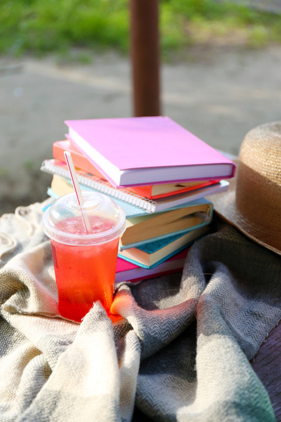 Books, hat and drink outdoors - Foto, Imagen