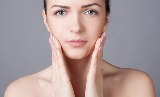 Close-up portrait of a beautiful young woman. Skin care concept. Natural look. Beauty portrait. Spa and health. - Fotó, kép