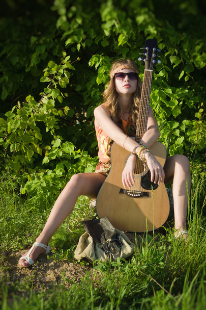 Atrakcyjna dziewczyna podróżujący z gitarą - Zdjęcie, obraz