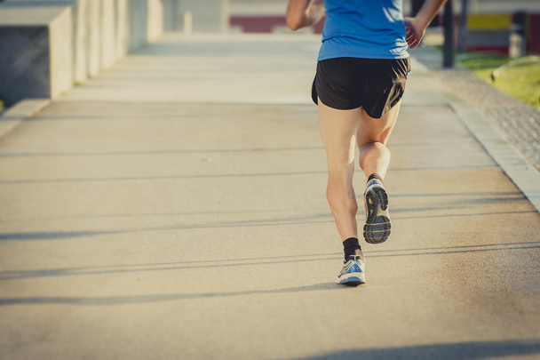 vista posterior de las piernas y los zapatos de hombre atlético joven corriendo en el entrenamiento de fitness de verano
 - Foto, Imagen