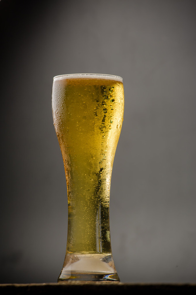 Üveg fekete háttéren világos sör - Fotó, kép