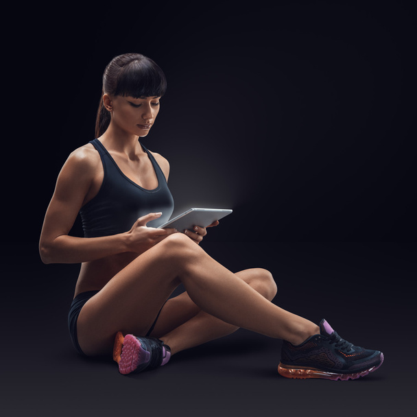 Fitness sporty woman using a digital tablet  - Φωτογραφία, εικόνα