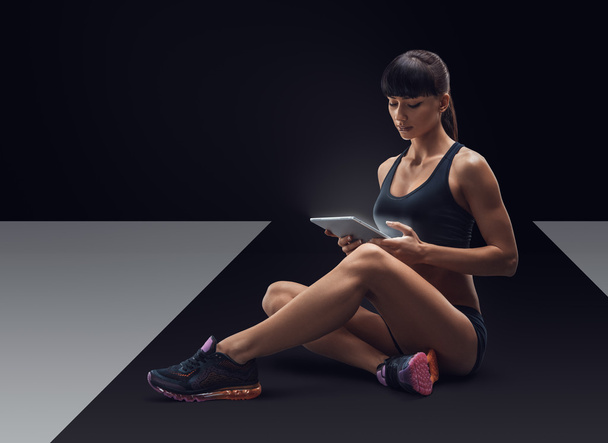 Fitness sporty woman using a digital tablet  - Fotoğraf, Görsel
