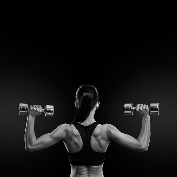 Fitness nainen treenaa lihaksia takaisin käsipainoilla
 - Valokuva, kuva