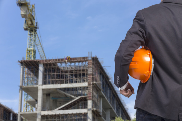 Ingenieur mit orangefarbenem Helm für die Sicherheit der Arbeiter auf Baustellen - Foto, Bild
