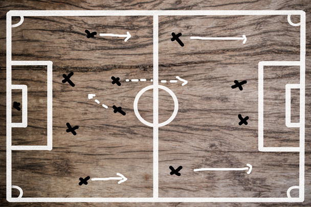Σχεδιασμός στρατηγικής ομάδα σε ένα ξύλο σχέδιο του ένα ποδόσφαιρο που να παίζει - Φωτογραφία, εικόνα