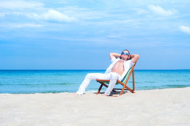 plajda şezlong üzerinde oturan adam - Fotoğraf, Görsel