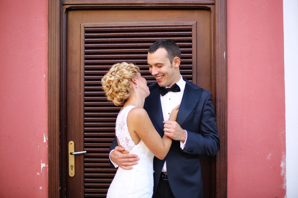 Bride and groom embracing near door - Photo, Image
