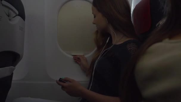 Dziewczyna otwiera okno samolotu - Materiał filmowy, wideo