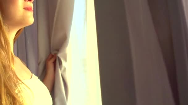 girl opens curtains on big window - Кадри, відео