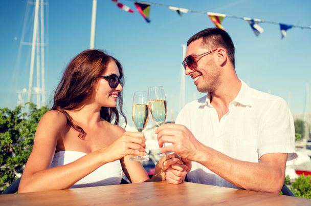 smiling couple drinking champagne at cafe - 写真・画像