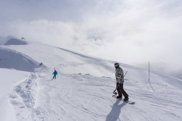 Esquiadores y snowboarders bajando la pendiente
. - Foto, imagen