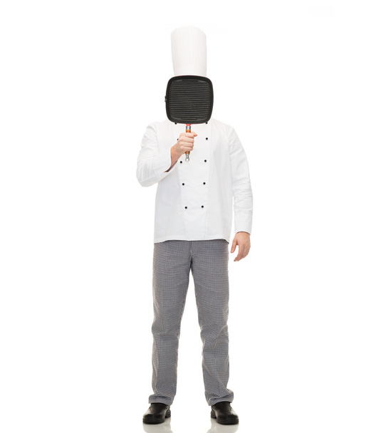 male chef cook covering face with grill pan - Фото, изображение
