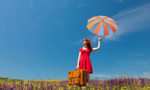 傘とスーツケースの赤いドレスを着た女性 - 写真・画像