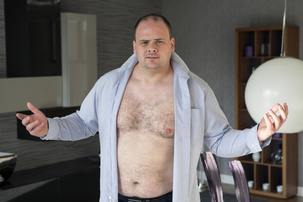 man standing in his living room with open shirt - 写真・画像