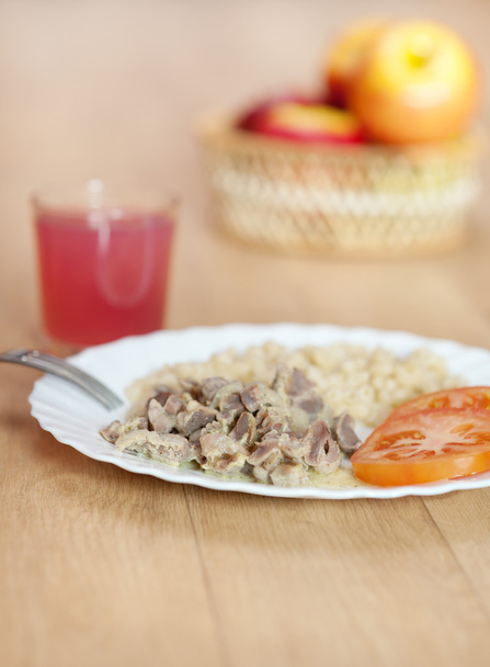 Вкусный ужин тушеная паста ломтики мяса томатные тарелки вилка стекло
 - Фото, изображение
