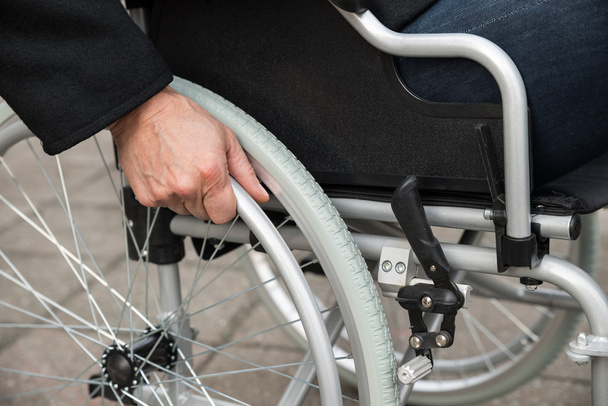 Άνδρας κάθεται στο αναπηρικό καροτσάκι - Φωτογραφία, εικόνα