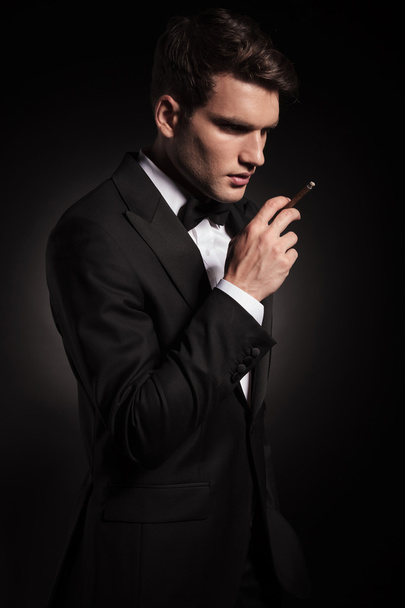 fiatal férfi tartja kezében a cigarettát. - Fotó, kép