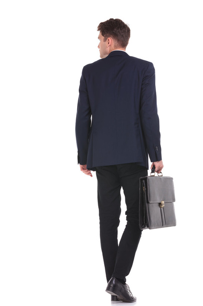 business man walking while holding his briefcase. - Φωτογραφία, εικόνα