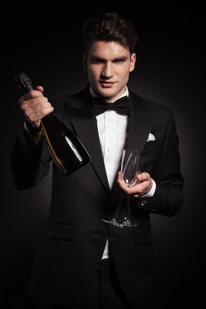 Elegantní pohledný muž, který držel láhev vína  - Fotografie, Obrázek