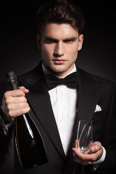 elegant young man holding two glasses  - Foto, afbeelding
