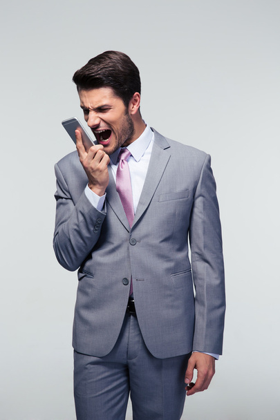 Confident businessman shouting on the phone - 写真・画像