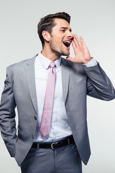Businessman shouting over gray background - Φωτογραφία, εικόνα
