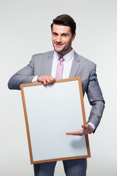 Happy businessman holding blank board  - Фото, изображение