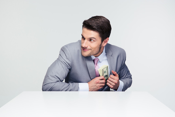 Businessman putting money in pocket - Foto, imagen